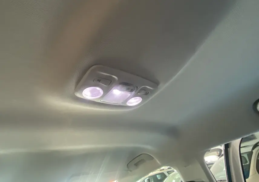 Plafonnier intérieur allumé du Peugeot 5008 blanc, vue du toit vers l'avant droit avec porte ouverte.