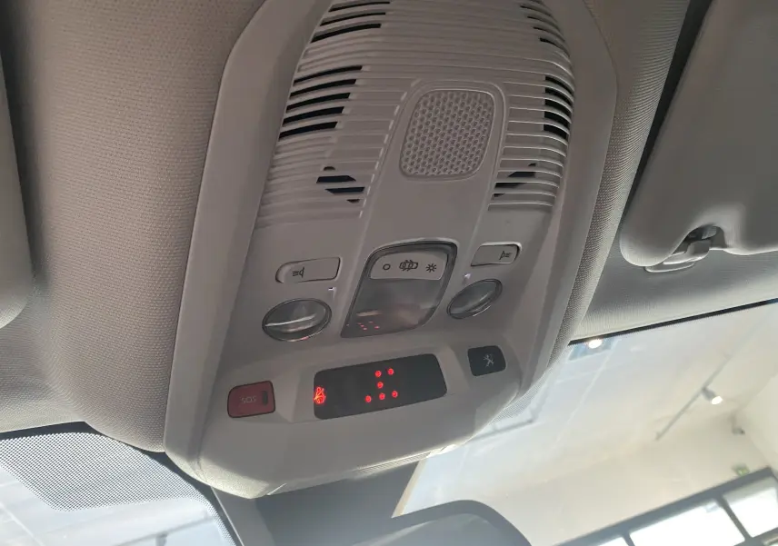Plafonnier intérieur gris clair du Peugeot 5008 II avec commandes d'éclairage et bouton SOS visible, vue en contre-plongée.