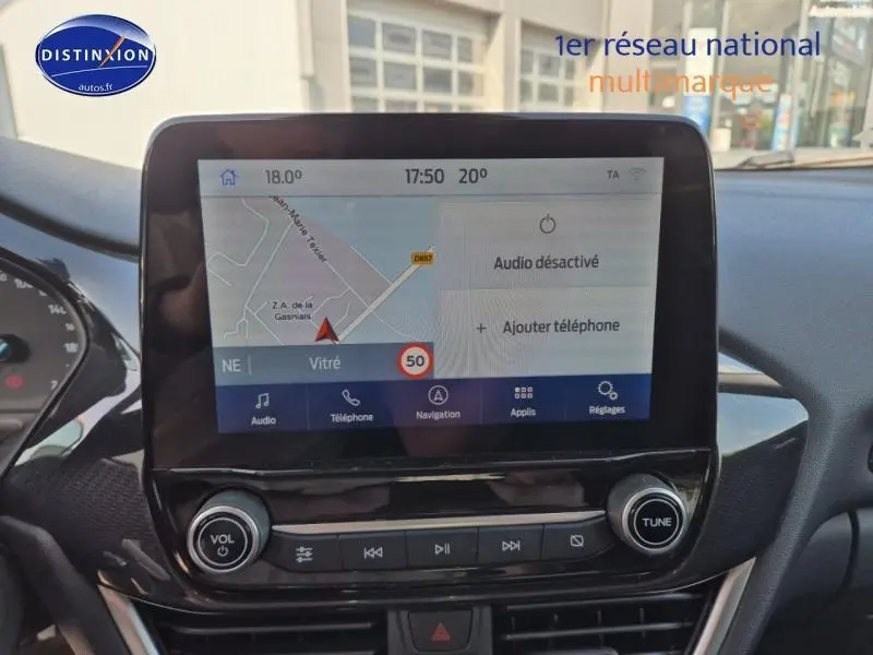 Écran tactile central avec navigation active dans l’habitacle d’une Ford Puma gris métallisé, vue de face rapprochée.