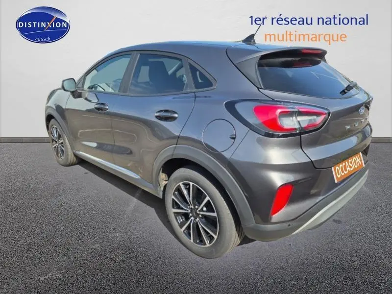 Vue 3/4 arrière droite d'une Ford Puma 1.0 EcoBoost gris métallisé avec jantes alu et feux LED arrière.