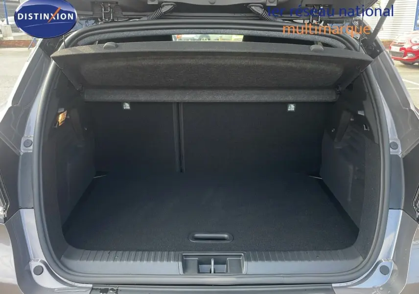 Coffre ouvert du Renault Captur E-Tech gris Cassiopée métal avec toit noir, vue arrière montrant l'espace de chargement vide.