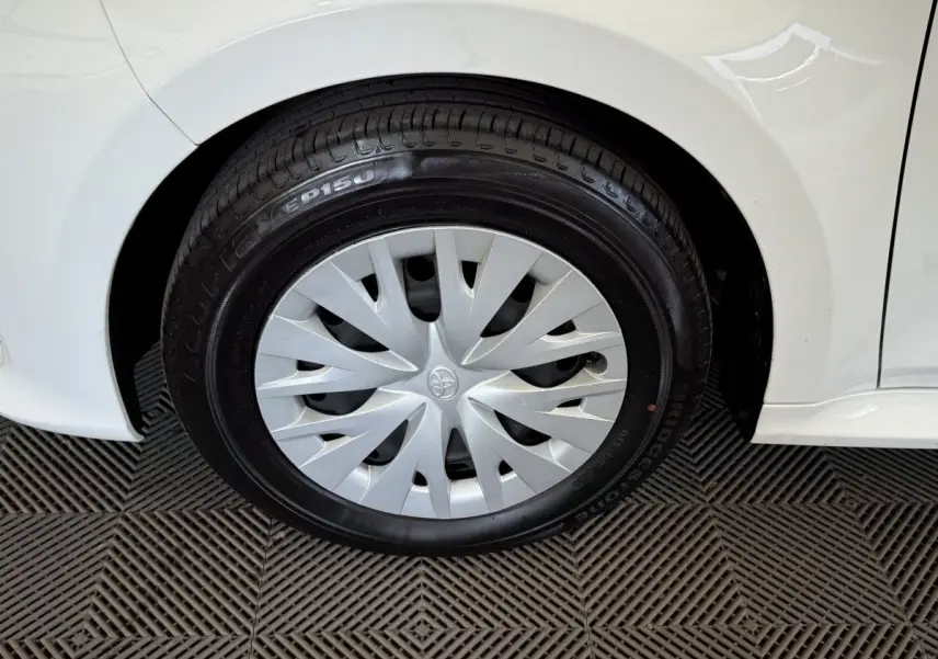 Gros plan sur la roue arrière droite blanche d'une Toyota Yaris hybride 2022 avec enjoliveur argenté et pneu Bridgestone.