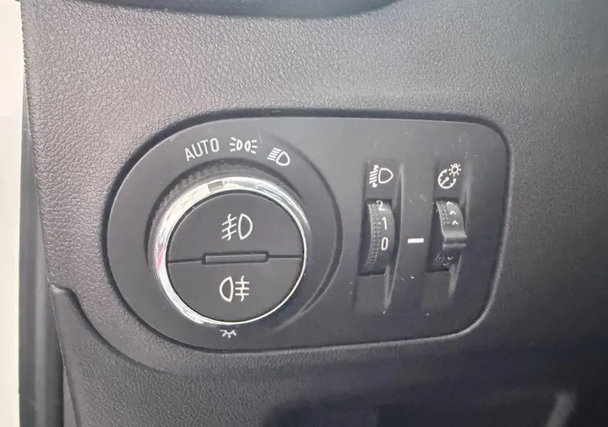 Gros plan sur les commandes d’éclairage intérieures noires de l’Opel Crossland blanc, avec sélecteur rotatif et réglages.