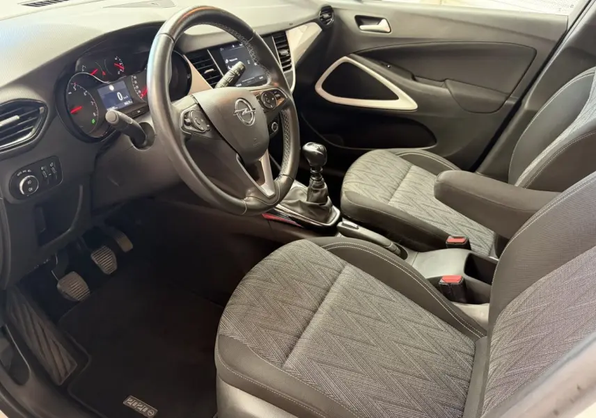 Vue intérieure côté conducteur de l'Opel Crossland 2021, volant cuir alu multifonctions et sièges tissu gris.