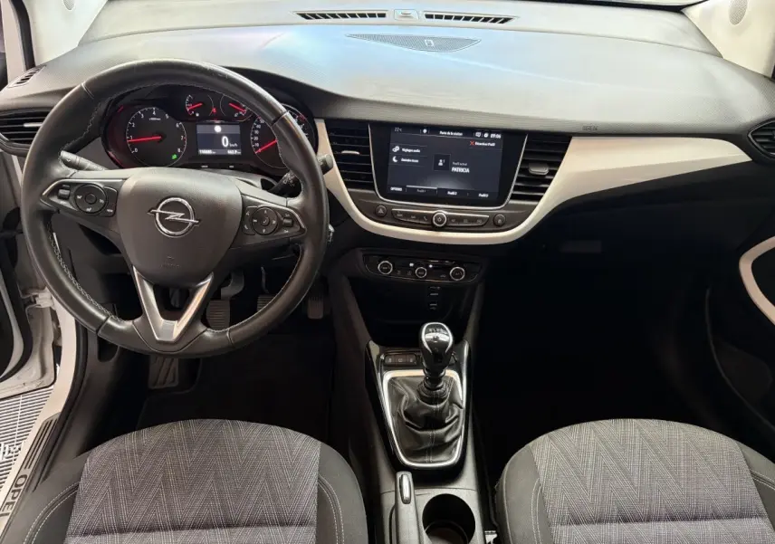 Vue intérieure avant de l’Opel Crossland 2021, volant cuir multifonctions, tableau de bord avec écran tactile et boîte manuelle.