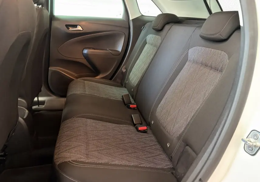 Vue côté droit de la banquette arrière grise et noire de l’Opel Crossland blanc, avec appuie-têtes et ceintures visibles.