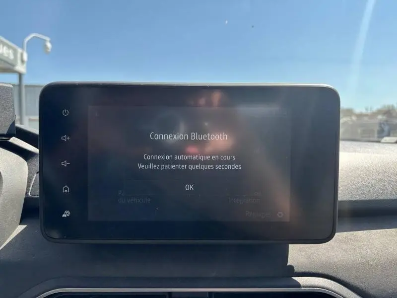 Écran tactile central de la Dacia Sandero 2025 affichant une connexion Bluetooth en cours, intérieur sobre.