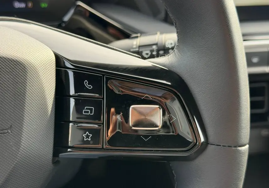Gros plan sur les commandes noires au volant cuir du MG3 1.5 Hybrid+ 195ch Luxury, finition Como Blue métallisé.