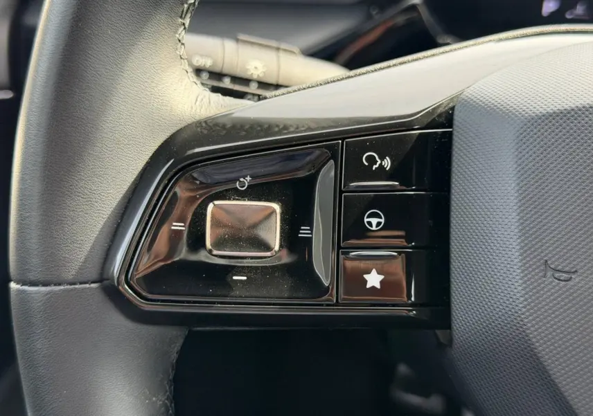 Gros plan sur les commandes noires à gauche du volant cuir noir du MG3 1.5 Hybrid+ Luxury 2025.