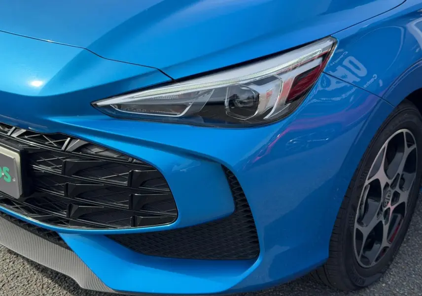 Gros plan sur l'avant droit du MG3 1.5 Hybrid+ 195ch Luxury en Como Blue métallisé avec phare LED et jante alu.