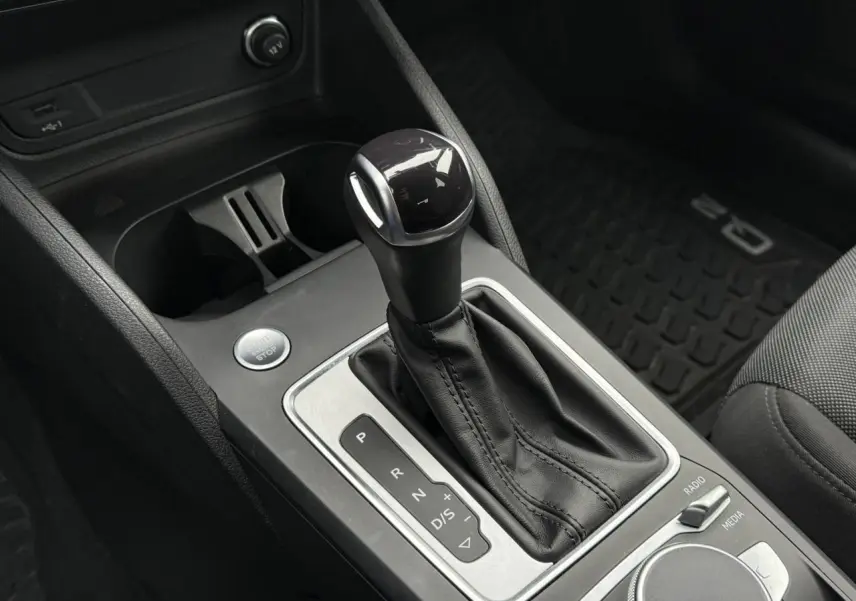 Gros plan sur le levier de vitesses automatique en cuir noir de l'Audi Q2 35 TFSI S-Line 2023.