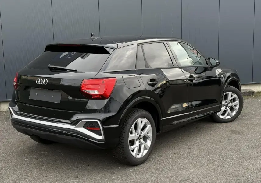 Audi Q2 35 TFSI S-Line noir Mythe vue 3/4 arrière droit, hayon électrique et jantes alliage 17 pouces visibles.