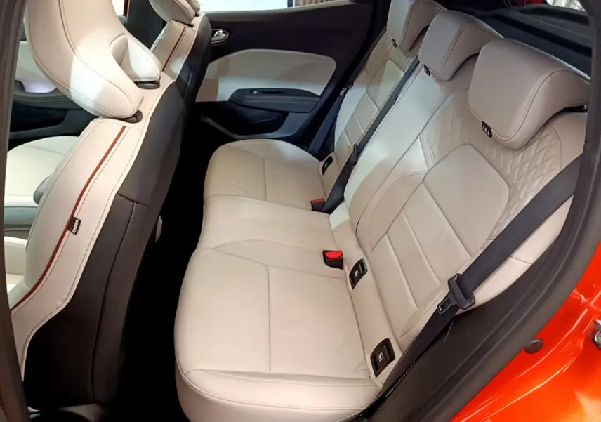 Vue latérale droite des sièges arrière en cuir beige de la Renault Clio Initiale Paris orange 2021, avec ceinture noire.