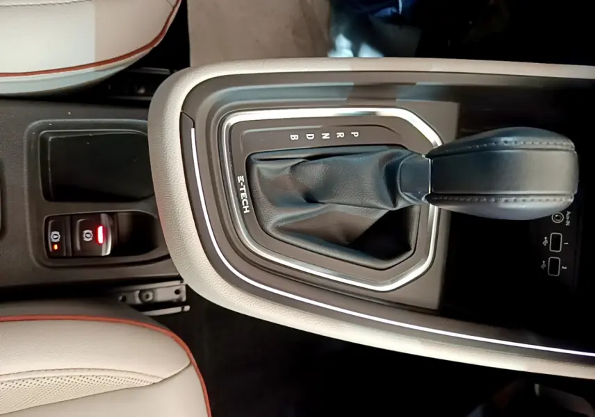 Gros plan sur la console centrale de la Renault Clio Initiale Paris E-TECH 140 avec levier de vitesses automatique et sellerie beige.