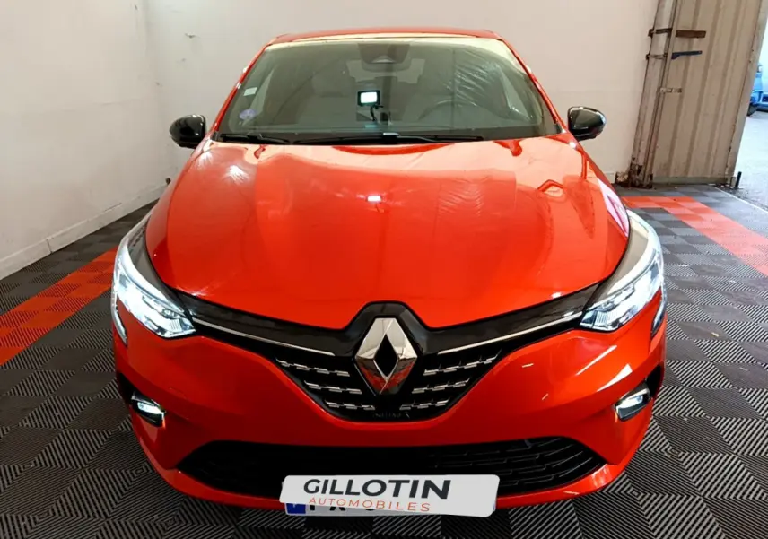 Vue frontale d'une Renault Clio Initiale Paris E-TECH 140 2021 orange avec phares LED et calandre noire brillante.