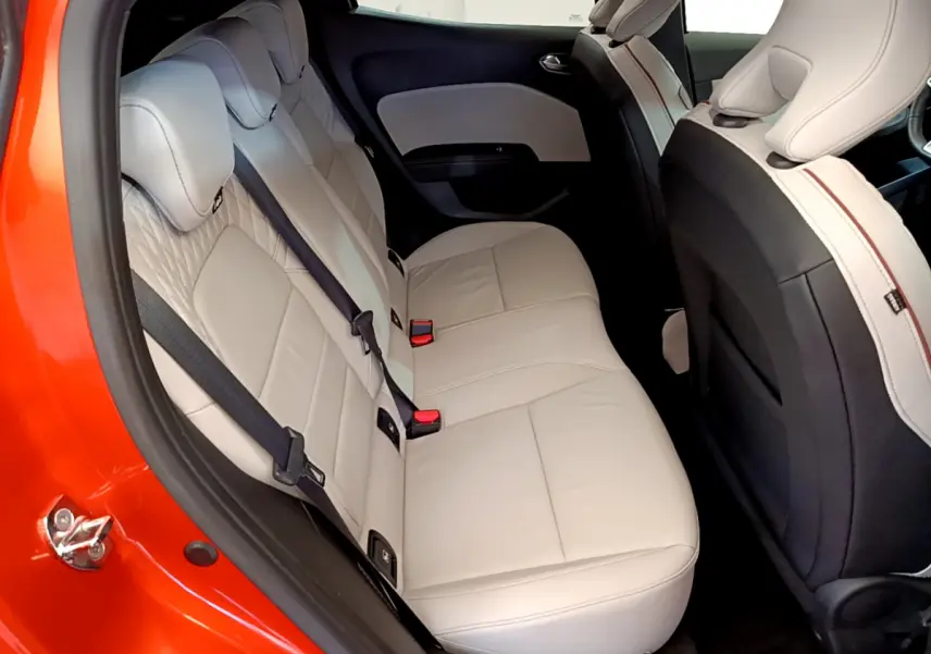 Vue intérieure côté gauche montrant la banquette arrière beige d'une Renault Clio orange 2021 Initiale Paris E-TECH.