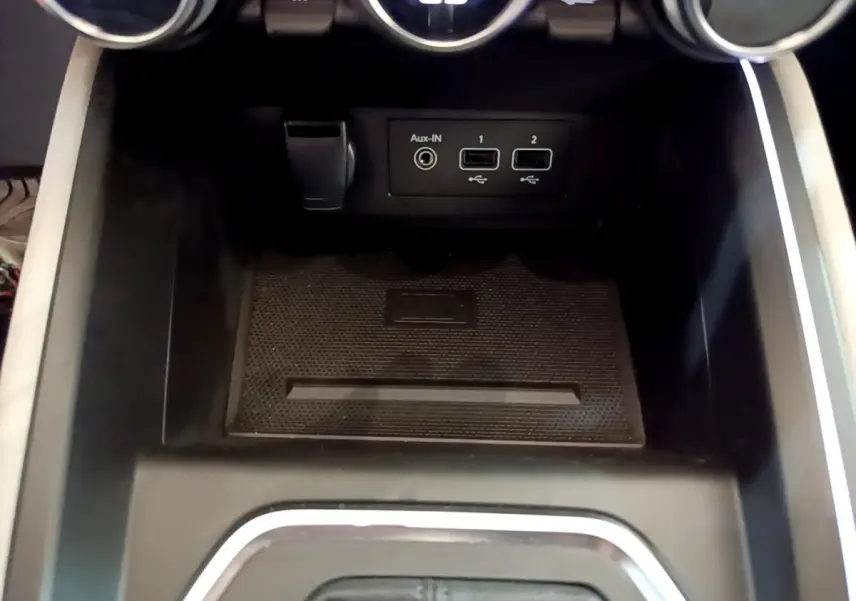 Gros plan sur la console centrale noire de la Renault Clio Initiale Paris E-TECH 140 avec ports USB et prise Aux-IN.