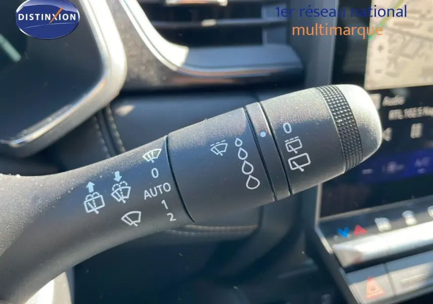 Gros plan sur la commande des essuie-glaces dans l’habitacle du Renault Symbioz noir étoile métal, avec tableau de bord en arrière-plan.