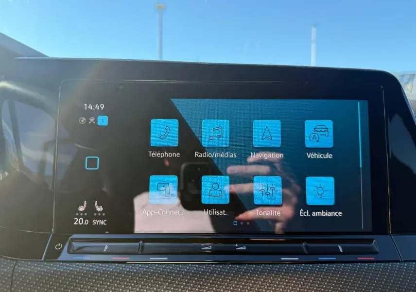 Écran tactile central de la Volkswagen Golf 2024 affichant le menu principal avec icônes bleues, vue de face.