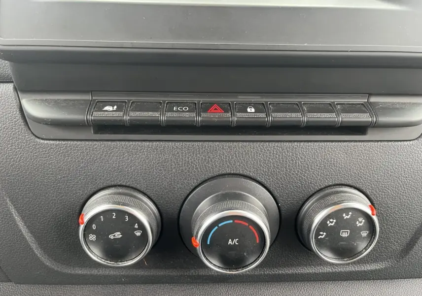 Commandes de climatisation et boutons de fonction du tableau de bord du Renault Master blanc, vue rapprochée.
