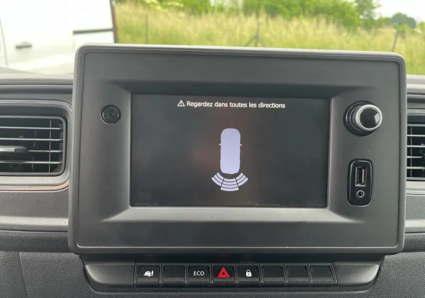 Écran central du tableau de bord du Renault Master blanc 2022 affichant l'alerte de détection d'obstacle arrière.