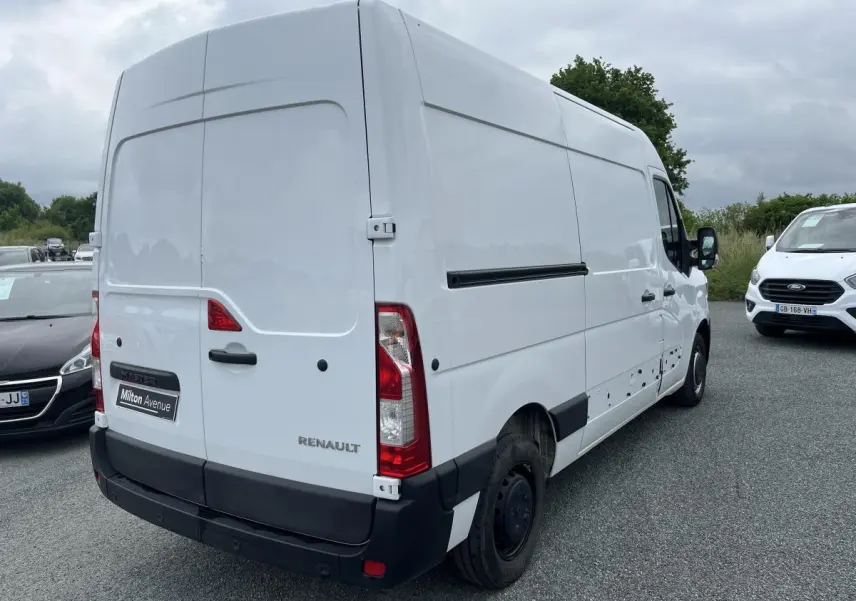 Renault Master blanc en vue 3/4 arrière droit, fourgon utilitaire avec portes arrière tôlées et jantes tôles noires.