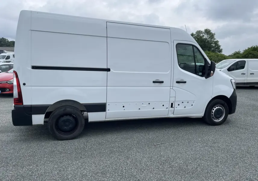 Profil droit d'un Renault Master blanc 2022, fourgon utilitaire avec porte latérale coulissante et jantes tôlées noires.