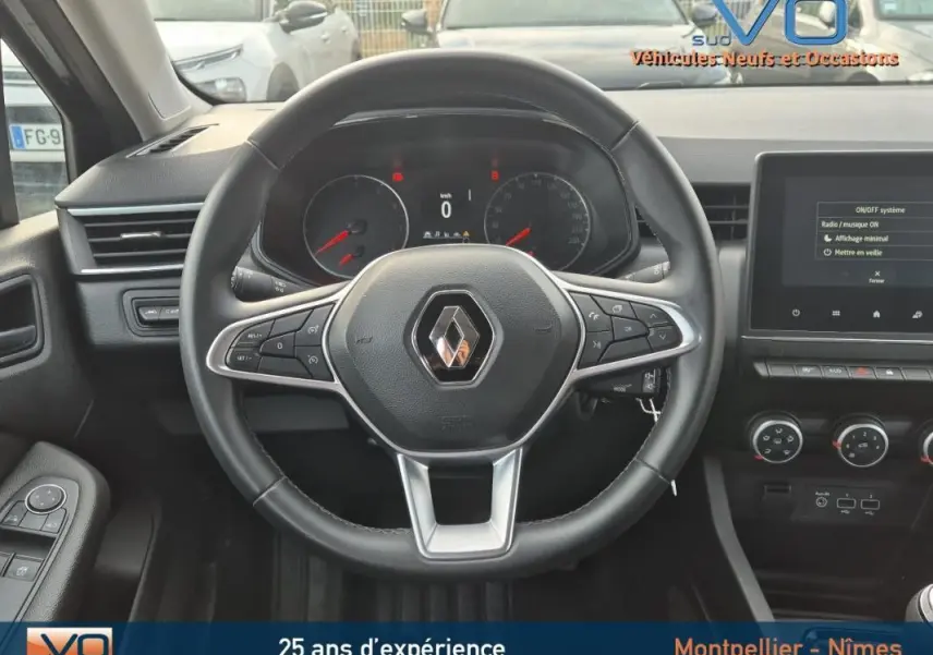 Vue intérieure centrée sur le volant Renault Clio noir 2023 avec commandes multifonctions et tableau de bord digital.
