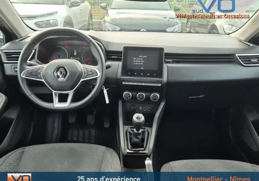 Vue intérieure frontale du tableau de bord et volant noir de la Renault Clio V TCe 90 Equilibre 2023 avec boîte manuelle.