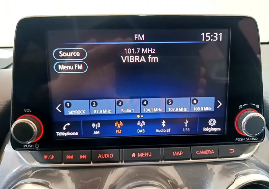 Écran tactile central 8 pouces du Nissan Juke Hybrid 143 Business+ 2023, affichant la radio FM en intérieur.