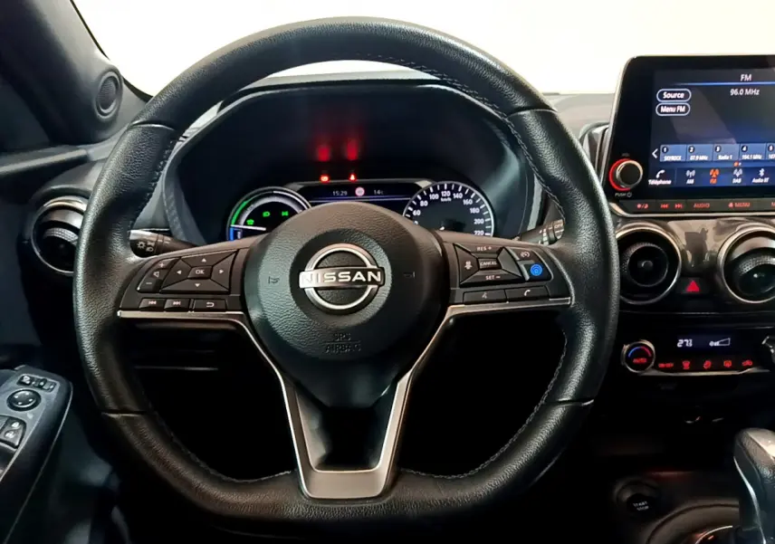 Vue rapprochée du volant en cuir noir et du tableau de bord numérique du Nissan Juke Hybrid 143 Business+ 2023.