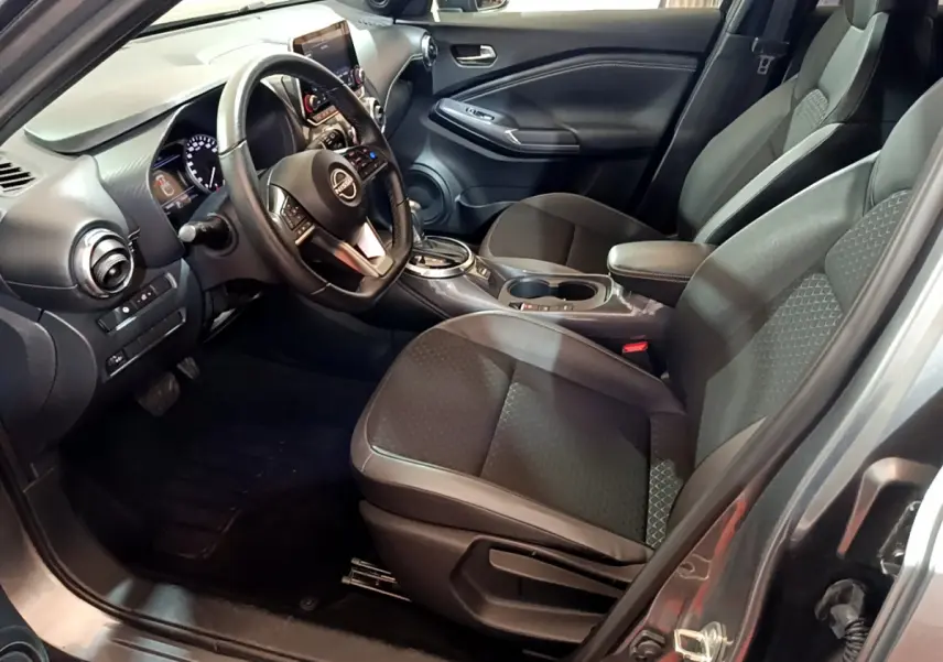 Intérieur avant droit du Nissan Juke Hybrid 143 Business+ 2023 avec sièges noirs et tableau de bord moderne.