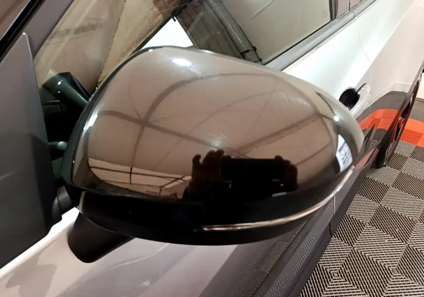 Rétroviseur droit noir brillant du Nissan Juke Hybrid gris foncé, vue rapprochée sur la portière côté droit.