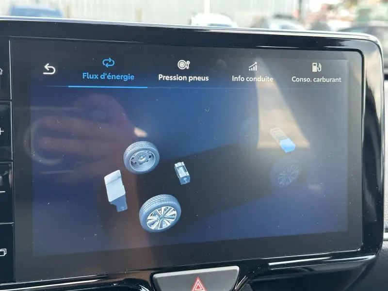 Écran tactile intérieur de la Toyota Yaris 116h Dynamic 2025 montrant le flux d'énergie hybride en mode graphique.