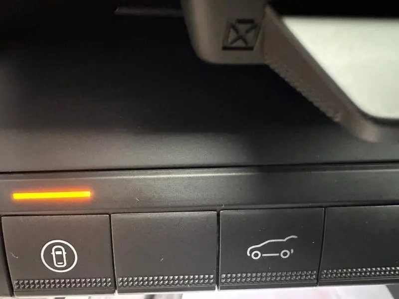 Gros plan sur les boutons de commande intérieurs noirs avec voyants orange, Renault Scenic E-Tech rouge 2025.