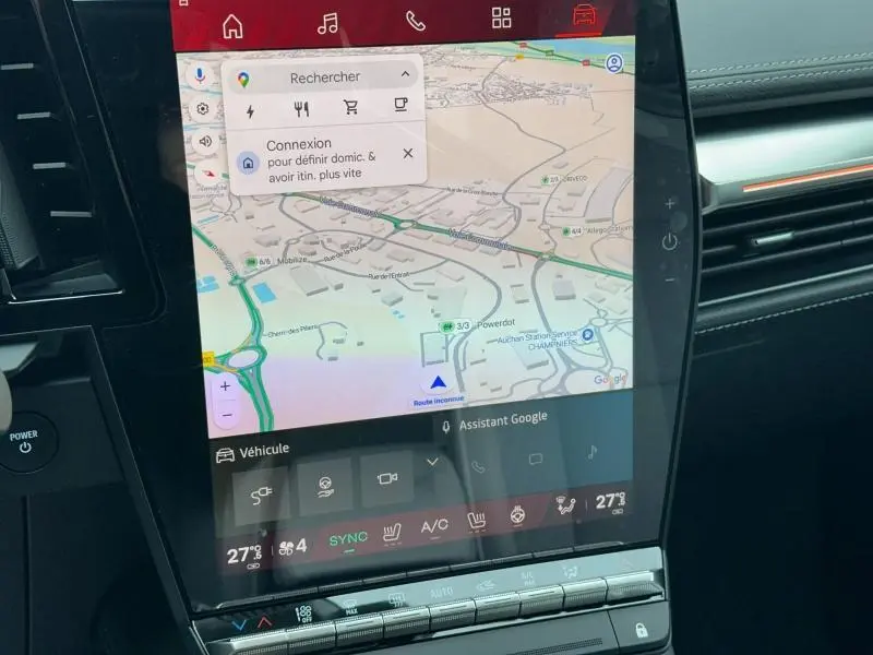 Gros plan sur l’écran tactile central du tableau de bord du Renault Scenic E-Tech rouge, affichant la navigation GPS.