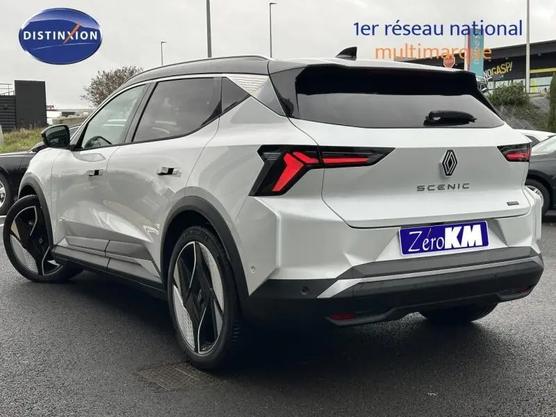 Vue 3/4 arrière droite d'un Renault Scénic E-Tech électrique blanc avec toit noir et feux arrière LED distinctifs.