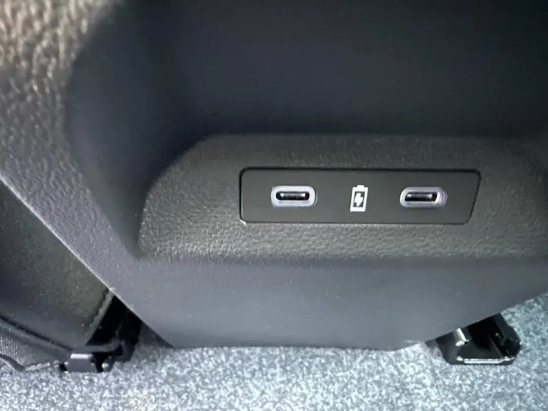 Gros plan sur deux ports USB-C noirs intégrés à la console arrière d’un Renault Scenic rouge.