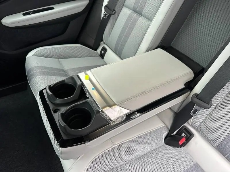 Vue rapprochée de l'accoudoir central arrière gris clair avec porte-gobelets sur la banquette arrière grise du Renault Scenic E-Tech 2025.