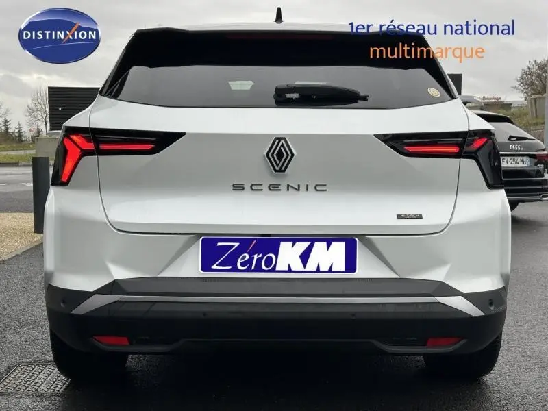 Vue arrière d'une Renault Scénic E-Tech électrique blanche avec feux LED distinctifs et logo central.