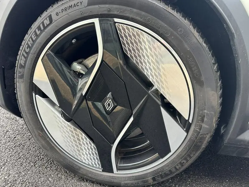 Gros plan sur la jante avant droite noire et argentée avec logo Renault, montée sur pneu Michelin e-Primacy.
