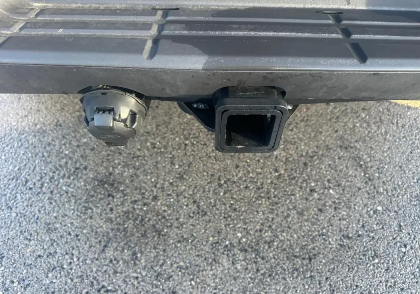 Gros plan sur l'attelage et la prise électrique arrière du Ford Ranger blanc, version Raptor 2025.