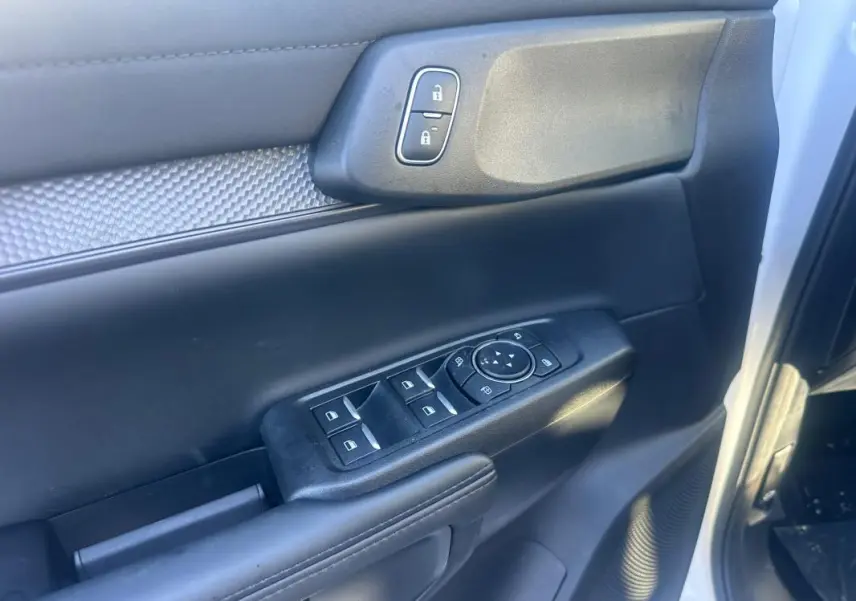 Gros plan sur la porte avant gauche du Ford Ranger blanc 2025, montrant les commandes des vitres et la serrure centralisée.
