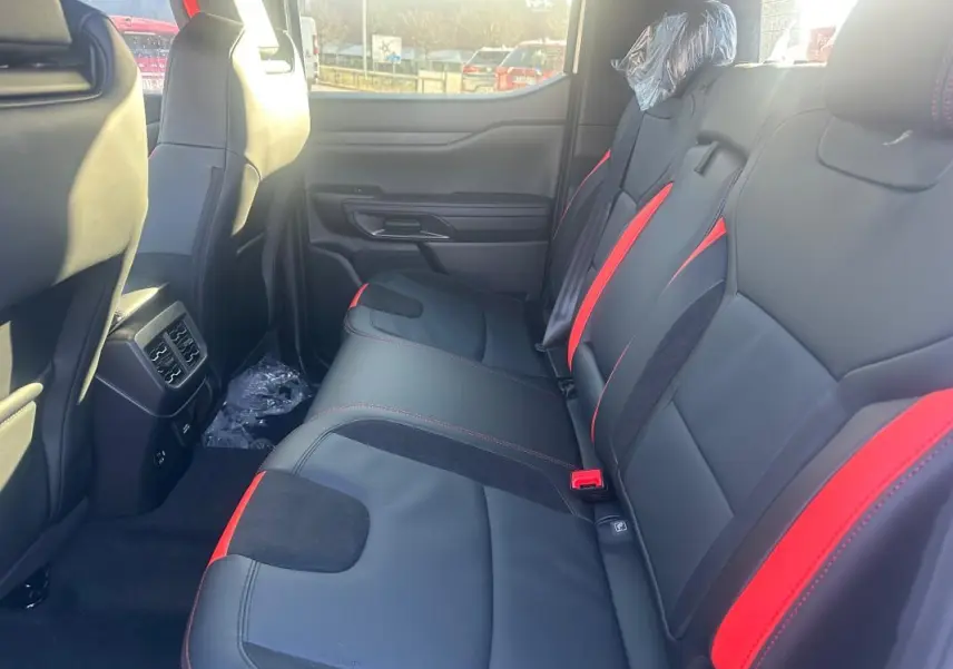 Vue intérieure côté droit des sièges arrière noirs avec surpiqûres rouges du Ford Ranger Double Cabine 2025.