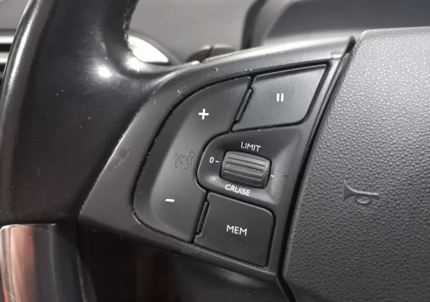 Gros plan sur les commandes de régulateur de vitesse au volant cuir noir du Citroën Grand C4 Spacetourer 2018.