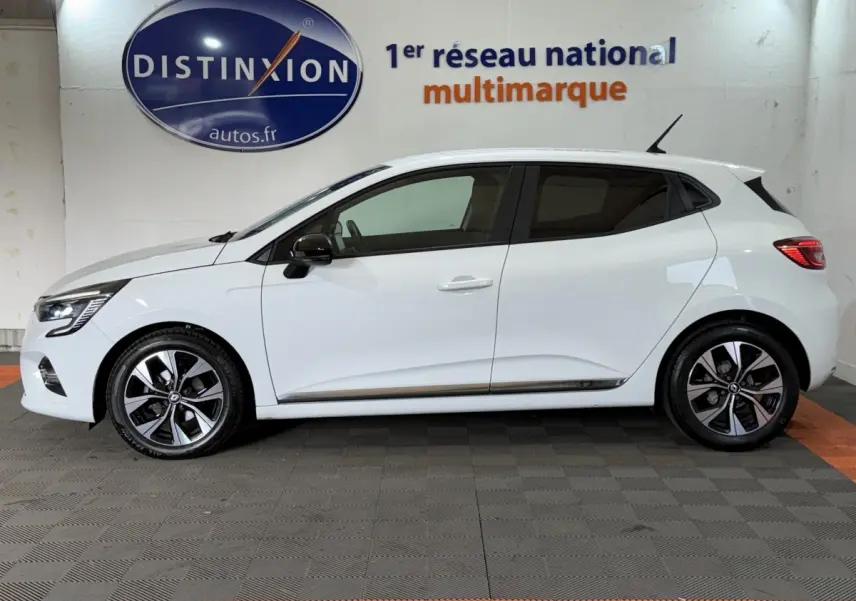 Profil droit d'une Renault Clio Business blanche, avec jantes alliage bicolores et rétroviseurs noirs.