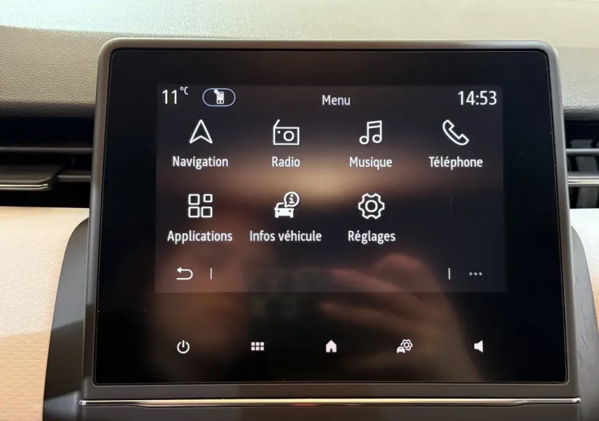 Écran tactile central de la Renault Clio Business blanc, affichant le menu principal avec navigation et musique.