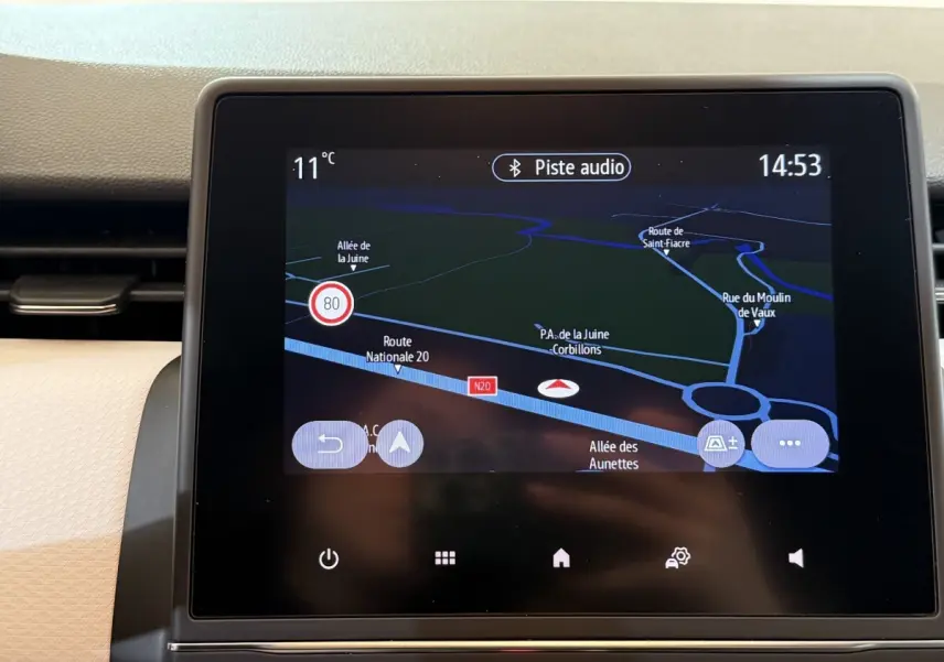 Écran tactile central de navigation 3D affichant une carte routière dans l'habitacle d'une Renault Clio blanche.