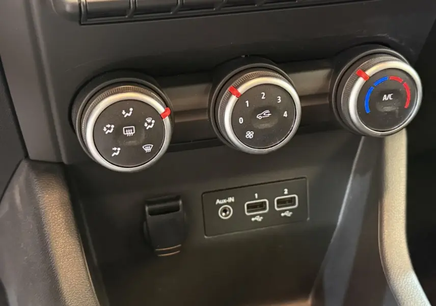 Gros plan sur les commandes de climatisation et les ports USB de la Renault Clio Business TCe 100 GPL blanche.