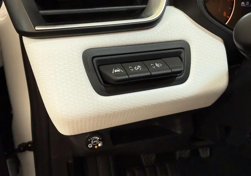 Détail intérieur côté gauche de la planche de bord blanche avec commandes d’aide à la conduite et bouton GPL allumé.